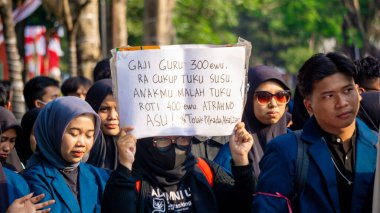 Öğrenciler, hanedan siyasetini ve seçim yasasındaki değişiklikleri reddettiklerini gösteren işaretler taşıyarak gösteri yapıyorlar..