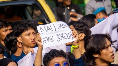 Öğrenciler, hanedan siyasetini ve seçim yasasındaki değişiklikleri reddettiklerini gösteren işaretler taşıyarak gösteri yapıyorlar..