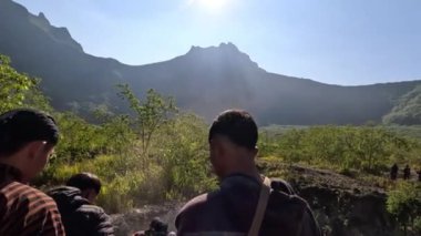 Bazı insanlar Kelud Dağı, Doğu Java, Endonezya 'daki kratere yürüyorlar.