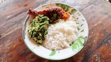 Endonezya yemeği. Pirinç ve urap-urap (acı biberli Endonezya salatası, rendelenmiş hindistan cevizi ve diğer baharatlar) ve kızarmış tavuk.
