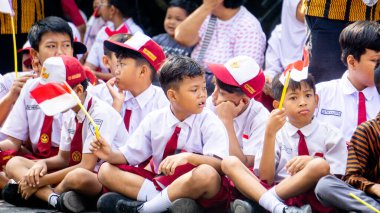 Endonezyalı üniformalı ilkokul öğrencileri Endonezya bayrağını sokaklara mutlulukla taşıdı