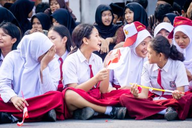 Endonezyalı üniformalı ilkokul öğrencileri Endonezya bayrağını sokaklara mutlulukla taşıdı