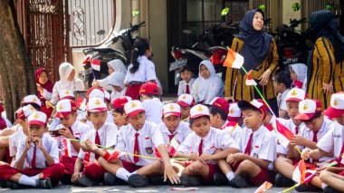 Endonezyalı üniformalı ilkokul öğrencileri Endonezya bayrağını sokaklara mutlulukla taşıdı