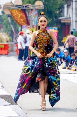 Girl with batik. Batik is a type of cloth motif originating from Indonesia and is an intangible cultural heritage that has been recognized by UNESCO. clipart