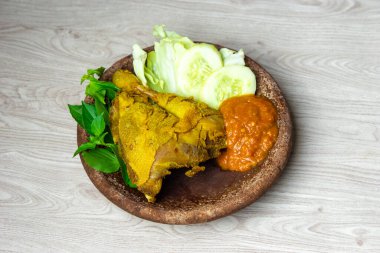 Indonesian fried chicken (Indonesian call it ayam Penyet, Penyetan Ayam). Usually served with tomato sauce, fried tempe, fried tofu, fried eggplant, cabbage, cucumber and Lemon basil clipart