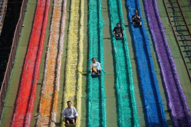 İnsanlar tatillerde Dusun Semilir 'de gökkuşağı slaytı oynuyorlar. Dusun Semilir Semarang 'da ünlü bir turistik merkezdir.