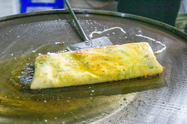 Şef geleneksel Endonezya yemeği olan yumurta martabak pişiriyor. Sebzeler, et ve çeşitli baharatlar ince bir hamur kabuğuna sarılıp kızartılır.