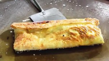 Şef geleneksel Endonezya yemeği olan yumurta martabak pişiriyor. Sebzeler, et ve çeşitli baharatlar ince bir hamur kabuğuna sarılıp kızartılır.