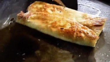 Şef geleneksel Endonezya yemeği olan yumurta martabak pişiriyor. Sebzeler, et ve çeşitli baharatlar ince bir hamur kabuğuna sarılıp kızartılır.