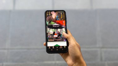 Bir el YouTube 'a kayıyor. YouTube 'da kısa bir şey aranıyor