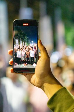 Hand akıllı telefonu tutuyor ve bir şeyler kaydediyor.