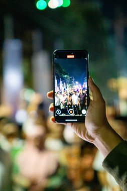 Hand akıllı telefonu tutuyor ve bir şeyler kaydediyor.