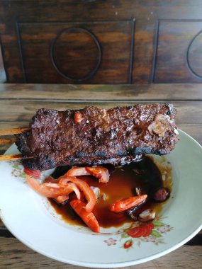 Satay sapi (sığır şişi). Soya sosu, acı biber ve domates ile servis edilir. Satay, Endonezya kökenlidir.