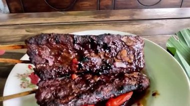 Satay sapi (sığır şişi). Soya sosu, acı biber ve domates ile servis edilir. Satay, Endonezya kökenlidir.
