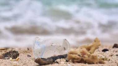 Plajda plastik atık. Ekolojik bir sorun. Bokeh arka planda dalgaları hareket ettiriyor