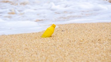 Plajda plastik atık. Ekolojik bir sorun. Bokeh arka planda dalgaları hareket ettiriyor
