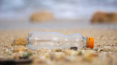 Plajda plastik atık. Ekolojik bir sorun. Bokeh arka planda dalgaları hareket ettiriyor