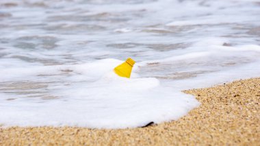 Plajda plastik atık. Ekolojik bir sorun. Bokeh arka planda dalgaları hareket ettiriyor