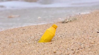 Plajda plastik atık. Ekolojik bir sorun. Bokeh arka planda dalgaları hareket ettiriyor