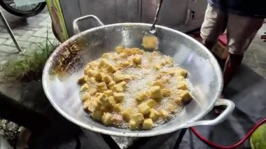 Bir satıcı müşteri için tofu pişiriyor. Endonezya sokak yemekleri.