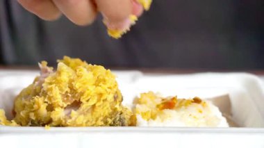 Ayam geprek yemek (Endonezya baharatlı kızarmış tavuk) pilavlı ve elleri köpüklü