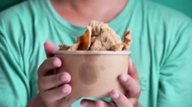 Kağıt bir kasede Keripik kulit ayam (tavuk derisi parçaları). Endonezya sokak yemekleri.