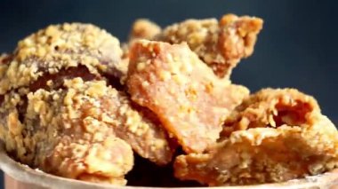 Kağıt bir kasede Keripik kulit ayam (tavuk derisi parçaları). Endonezya sokak yemekleri.