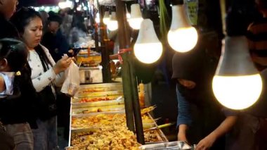 İnsanlar Kuno Kini Çarşısı 'ndan (Kediri Çarşısı) kızarmış yiyecek satın alıyor.)