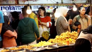 İnsanlar Kuno Kini Çarşısı 'ndan (Kediri Çarşısı) kızarmış yiyecek satın alıyor.)