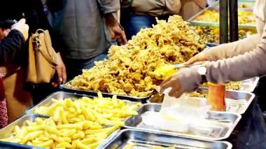 İnsanlar Kuno Kini Çarşısı 'ndan (Kediri Çarşısı) kızarmış yiyecek satın alıyor.)