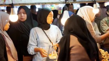 İnsanlar Kuno Kini Çarşısı 'ndan (Kediri Çarşısı) kızarmış yiyecek satın alıyor.)