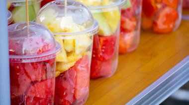 Plastik bardaklarda çeşitli meyveler. İnsanlar için sağlıklı yiyecek..