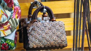 Duvarda hindistan cevizi kabuğundan yapılmış etnik çanta asılı.