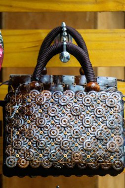 Duvarda hindistan cevizi kabuğundan yapılmış etnik çanta asılı.