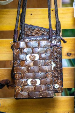 Duvarda hindistan cevizi kabuğundan yapılmış etnik çanta asılı.