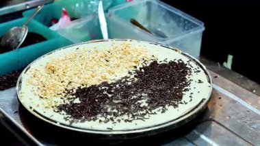 Yiyecek pazarında çeşitli farklı dolgularla dolu çıtır krep yapma süreci.