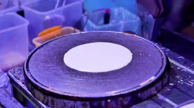 Yiyecek pazarında çeşitli farklı dolgularla dolu çıtır krep yapma süreci.