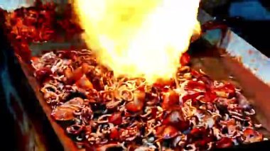 Satıcı kuyrukta bekleyen müşteriler için ızgara kalamar pişirir..