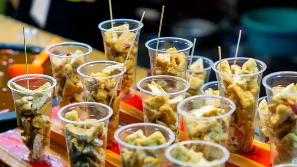 Plastik bardakta Tahu Gejrot. Tahu Gejrot, Endonezya 'nın baharatlı tatlı soslu soya peyniri.