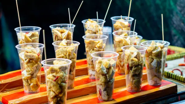 Plastik bardakta Tahu Gejrot. Tahu Gejrot, Endonezya 'nın baharatlı tatlı soslu soya peyniri.