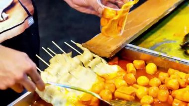 Tteokbokki, baharatlı ve tatlı gochujang baharatında pişirilmiş Kore pirinç unu. Sokak Kore yemekleri.