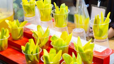 Plastik bardakta turşulu mango. Tipik bir Endonezya aperatifi, sirke, tuz, şeker ve baharat solüsyonuna batırılmış, dilimlenmiş genç mangodan yapılır..