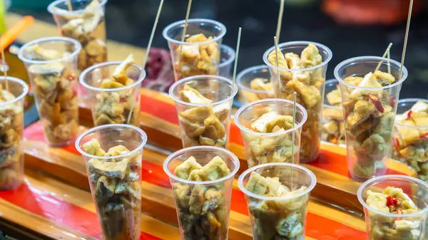 Plastik bardakta Tahu Gejrot. Tahu Gejrot, Endonezya 'nın baharatlı tatlı soslu soya peyniri.