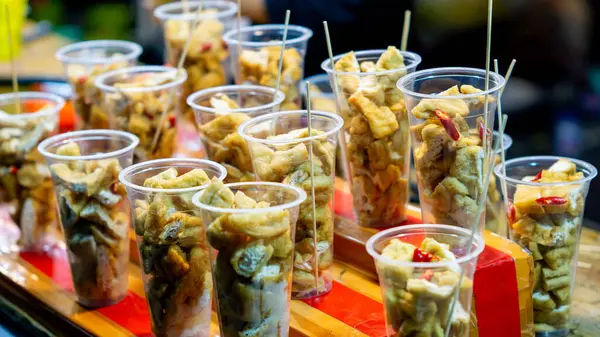 Plastik bardakta Tahu Gejrot. Tahu Gejrot, Endonezya 'nın baharatlı tatlı soslu soya peyniri.