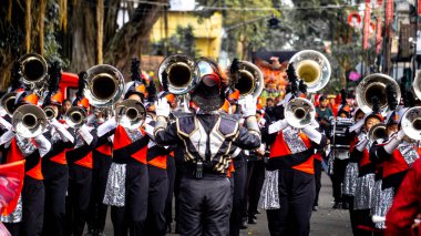 Bir bateri grubu festival sırasında otobanda yürürken müzik aletleri çalıyor