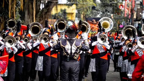 Bir bateri grubu festival sırasında otobanda yürürken müzik aletleri çalıyor