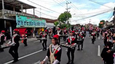Bir bateri grubu festival sırasında otobanda yürürken müzik aletleri çalıyor