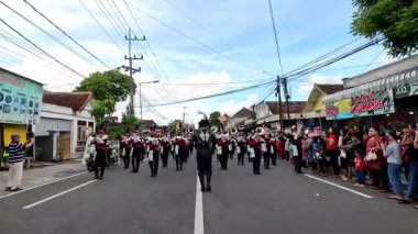 Bir bateri grubu festival sırasında otobanda yürürken müzik aletleri çalıyor