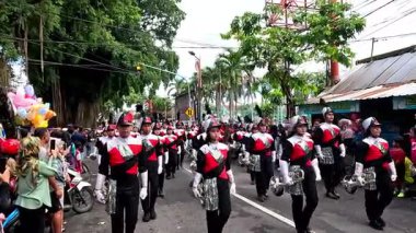 Bir bateri grubu festival sırasında otobanda yürürken müzik aletleri çalıyor