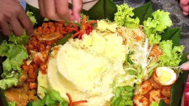 Eller nasi tümörünü alıyor. Nasi tumpeng genellikle Şükran Günü 'nde ya da belirli bir etkinlikte verilen pirinçtir..